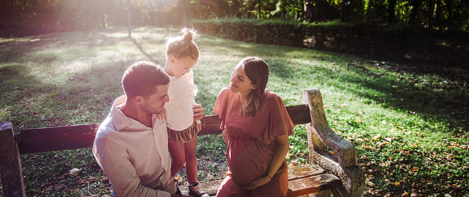 Famille avec enfant assise sur un banc dans le parc des îles à vermenton lors d’une séance photo en extérieur en Bourgogne