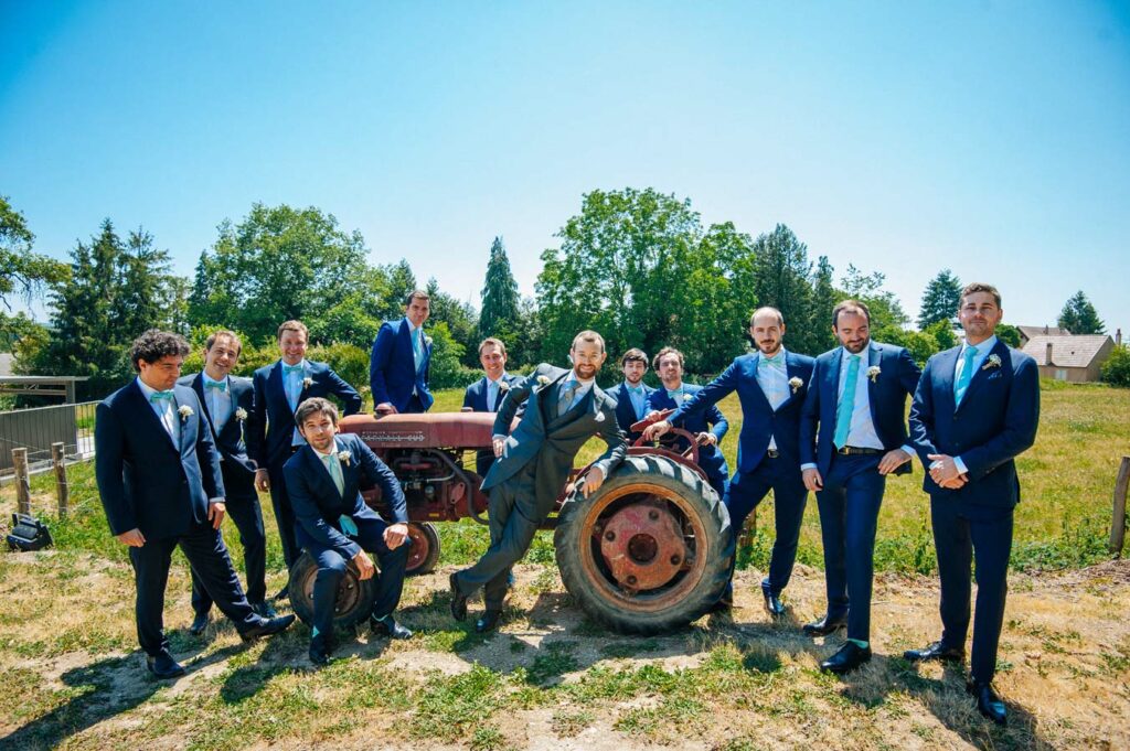 Portrait de groupe des garçons d’honneur autour d’un tracteur dans la campagne lors d’un mariage en Bourgogne