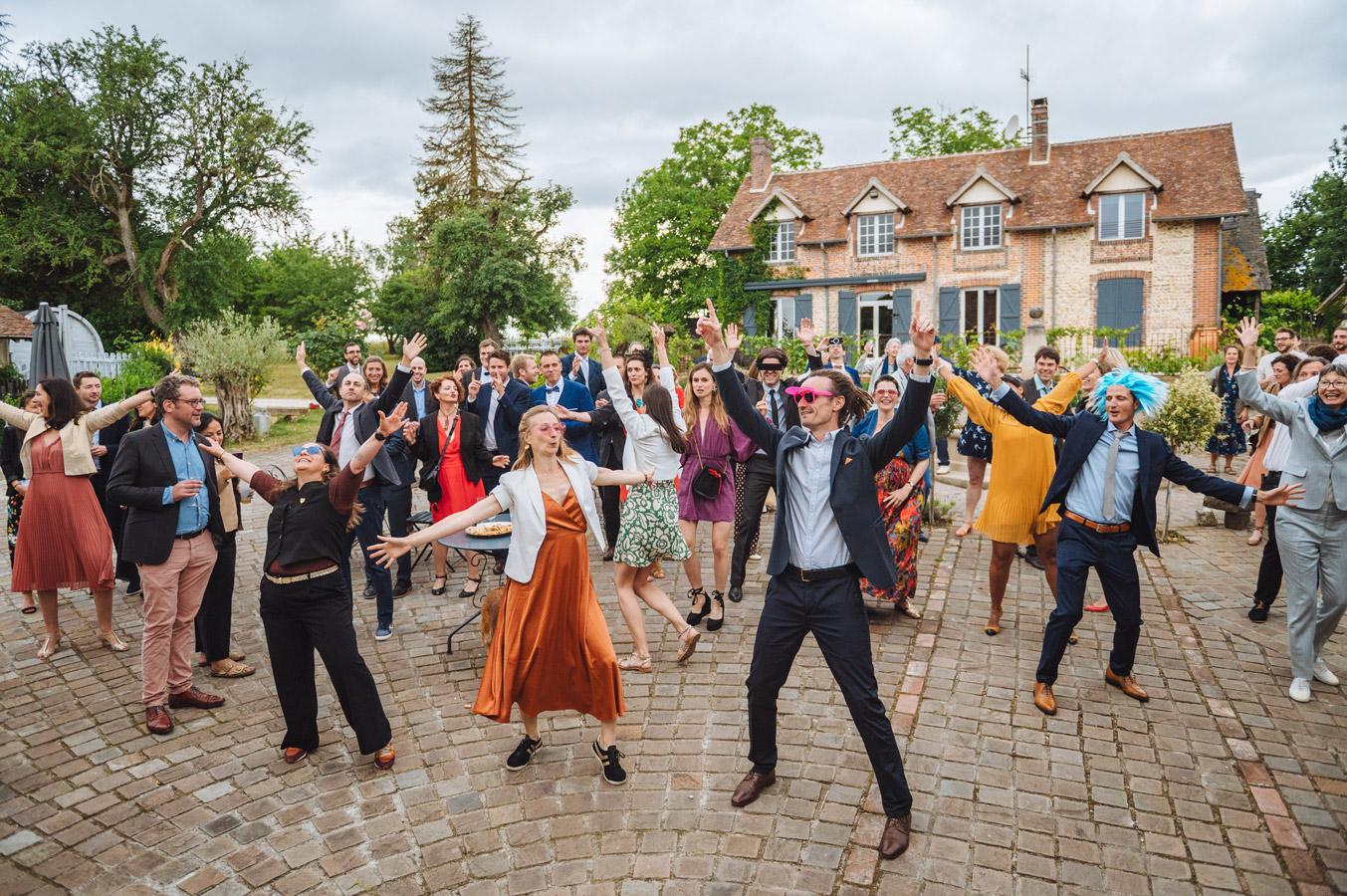 Invités dansant dans la cour du Domaine Les Maisons Blanches à Champignelles lors d’un mariage dans l’Yonne