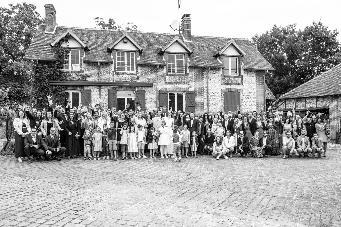 Photo de groupe des invités devant le Domaine Les Maisons Blanches à Champignelles lors d’un mariage dans l’Yonne