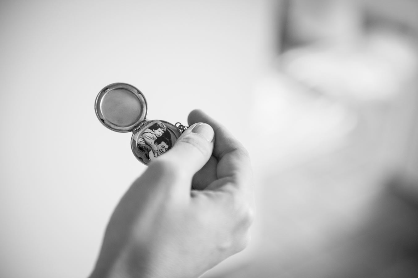Médaillon avec photo souvenir tenu dans la main de la mariée pendant les préparatifs du mariage