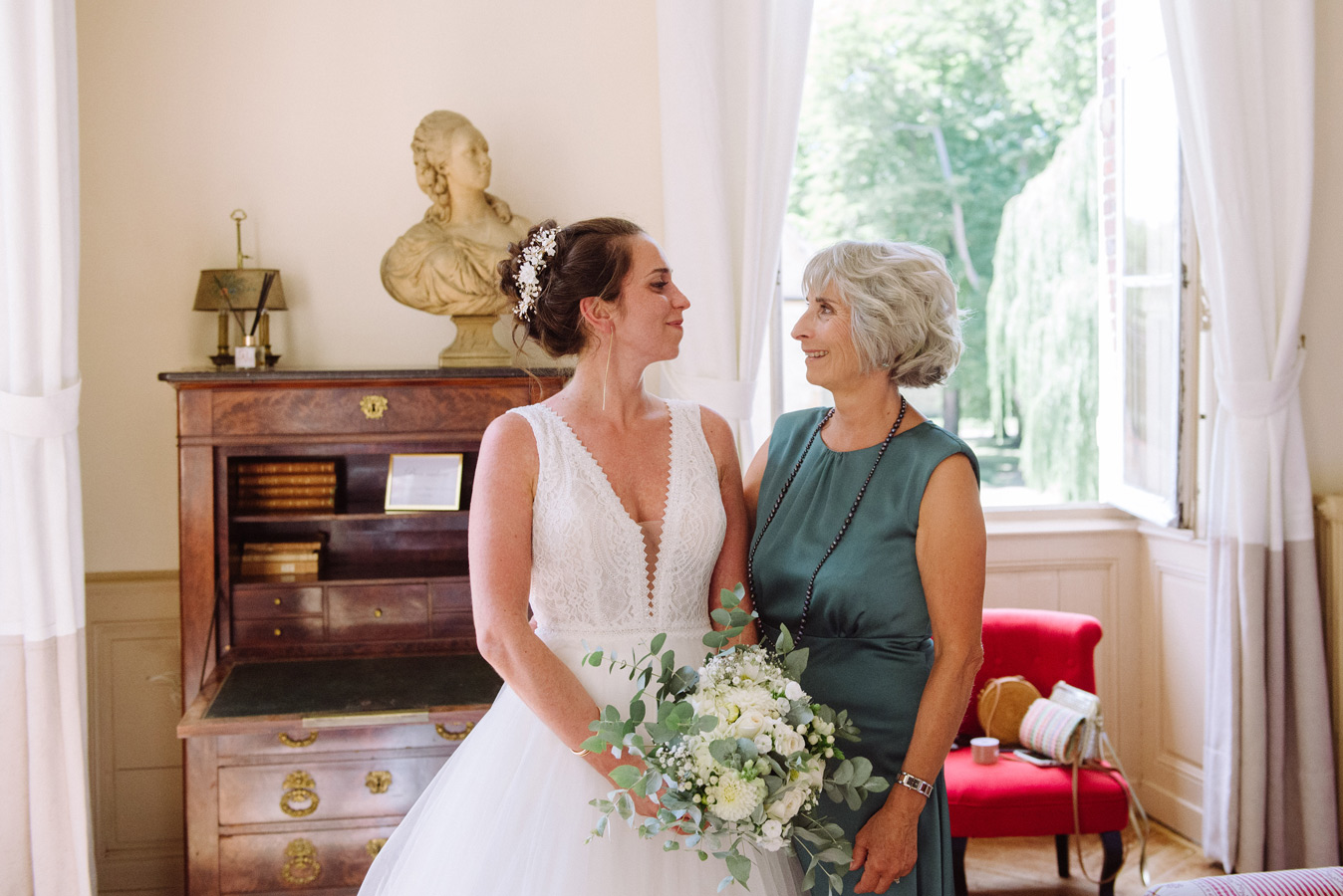 Mariée avec sa mère tenant son bouquet pendant les préparatifs de mariage
