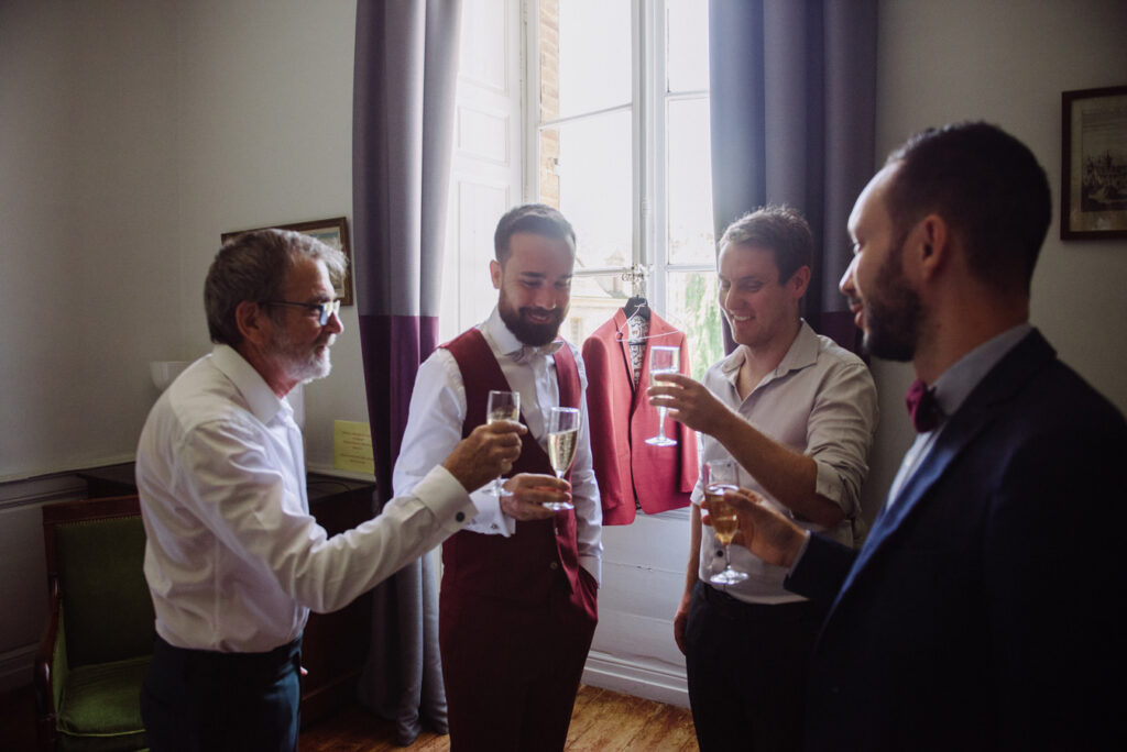 Marié et ses proches trinquant au champagne lors des préparatifs de mariage