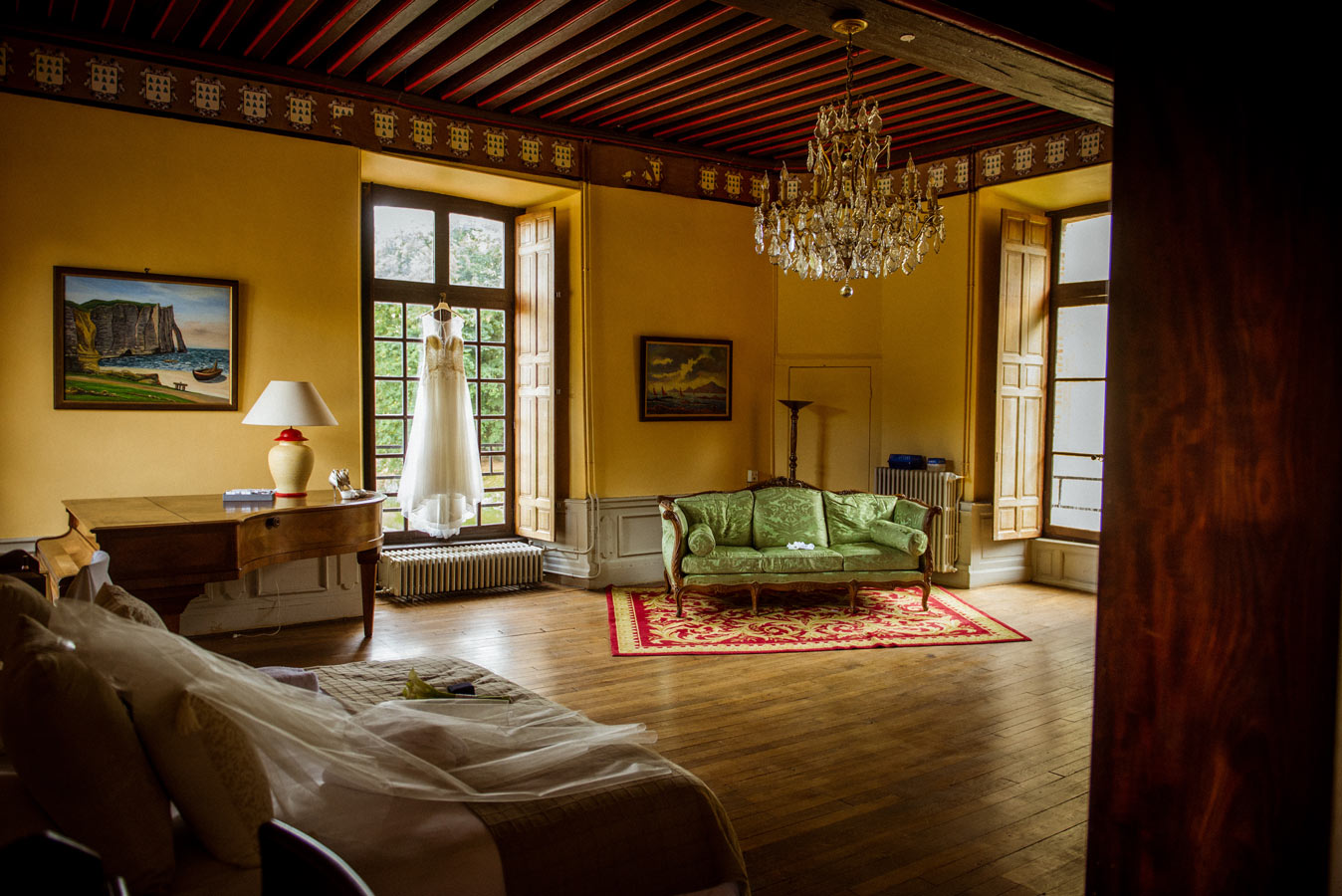 Robe de mariée suspendue à une fenêtre dans un château pendant les préparatifs du mariage